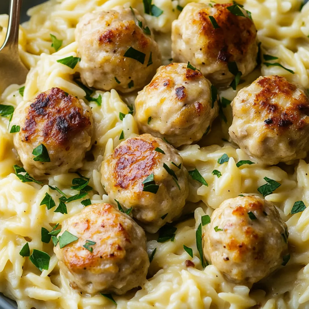 Schüssel voll mit Pasta, Bällchen und Gemüse.