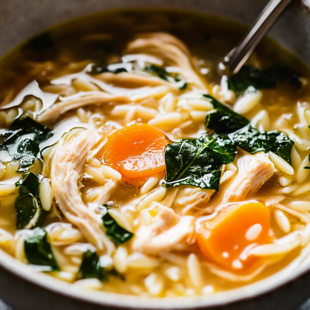 Eine dampfende Schüssel Hühnersuppe mit Gemüse.