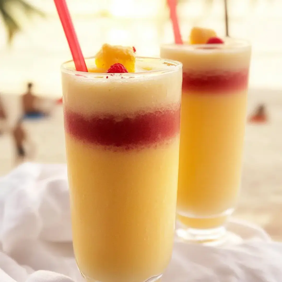 Zwei Gläser Orangensaft mit Trinkhalmen.