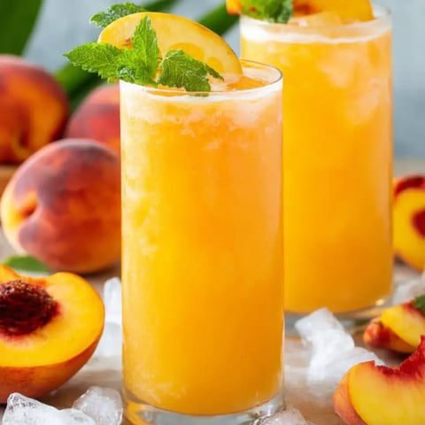 Zwei Gläser Pfirsichsaft mit Minzdeko.