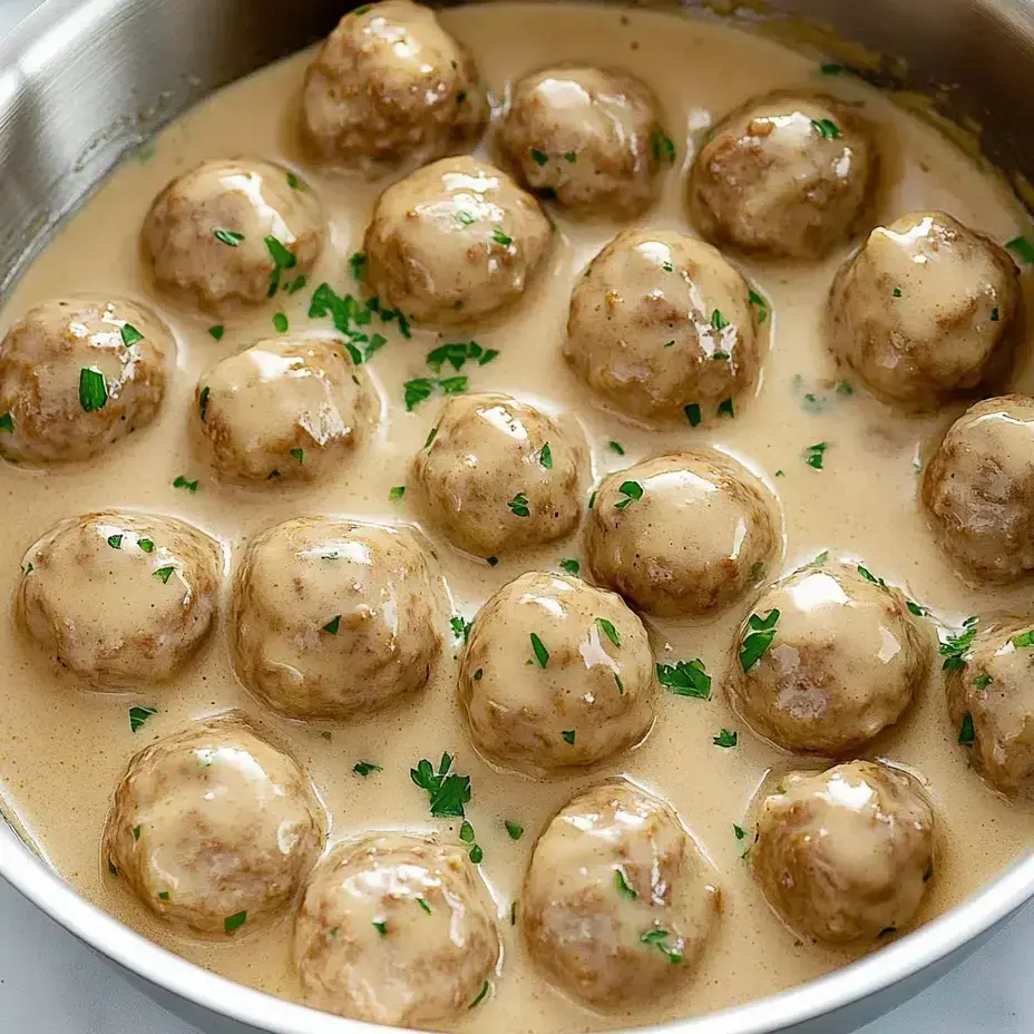 Eine Schüssel mit Fleischbällchen in cremiger Soße.
