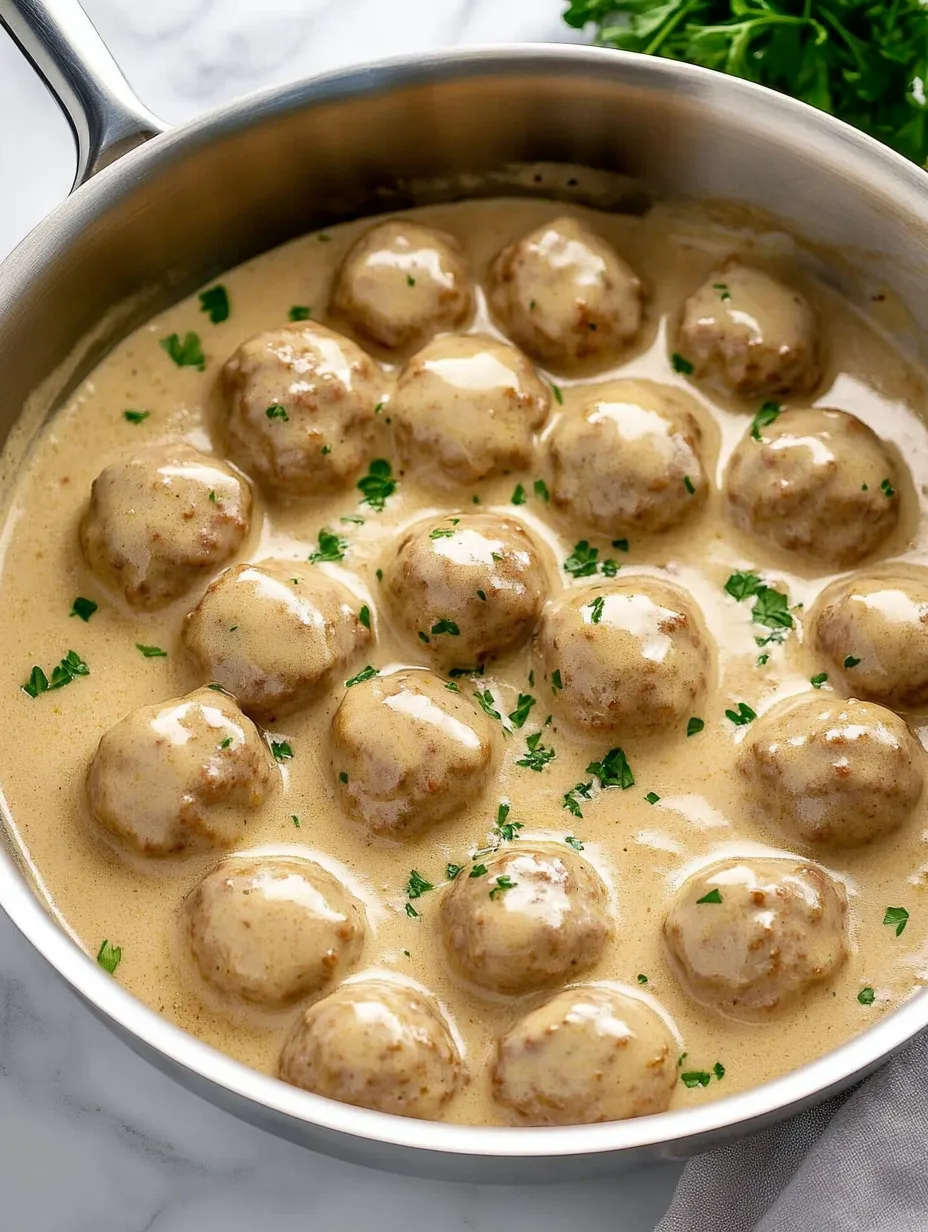Ein Topf mit Essen, Fleischbällchen und einem grünen Kraut.