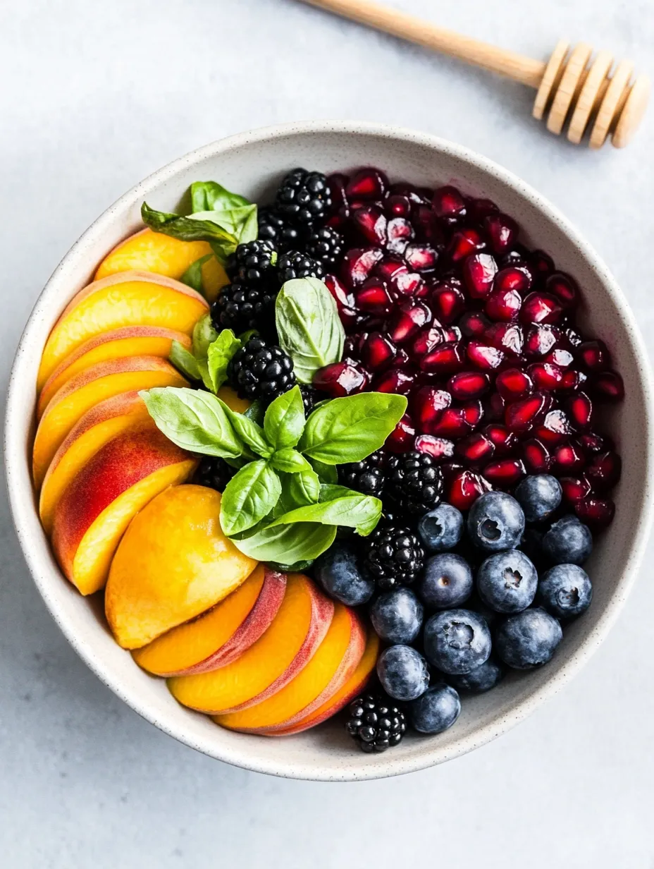 Schale mit Heidelbeeren, Himbeeren, Pfirsichen und Brombeeren.