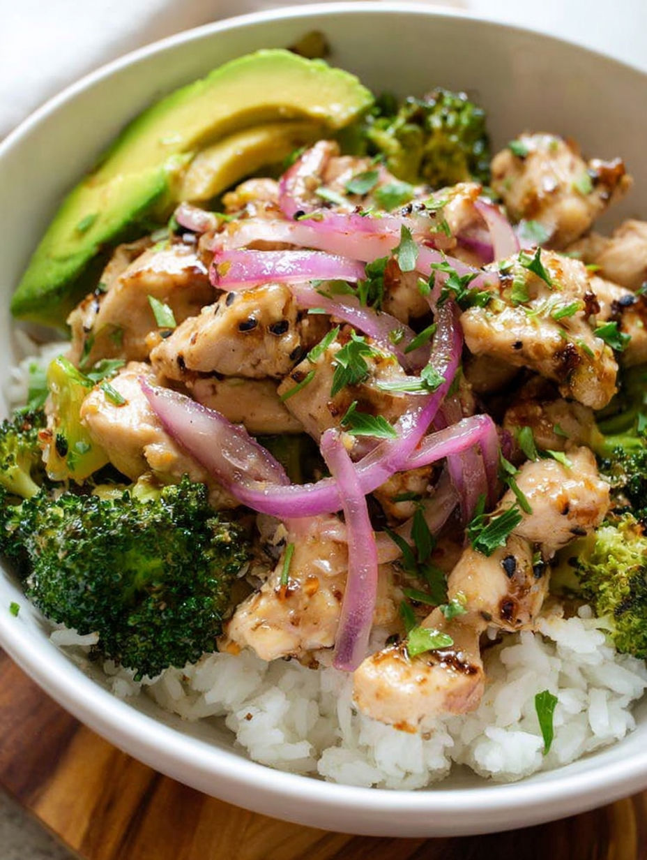 Schüssel mit Hähnchen und Brokkoli und Reis daneben.
