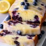 Ein Stück saftiger Kuchen mit Blaubeeren und Zitrone oben drauf.