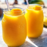 Zwei Gläser mit orangem Saft auf einem Tisch.