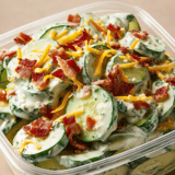 Schale mit gefüllten Gurken und Cheddar-Speck-Topping.