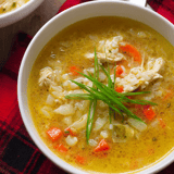 Eine Schale Suppe mit grünem Kraut obendrauf.