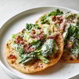 Ein Teller mit Salatblättern und Bacon.