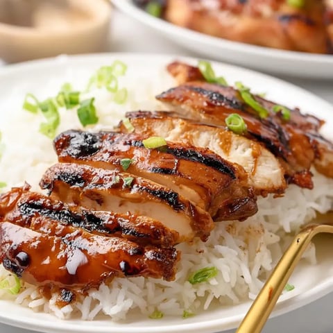 Ein Teller mit Reis und darauf Hühnchen.