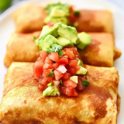 Ein Teller mit Chimichangas und Salsa obendrauf.