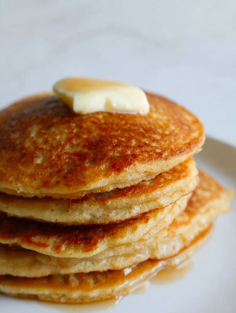 Ein Stapel Pfannkuchen mit Butter oben drauf.