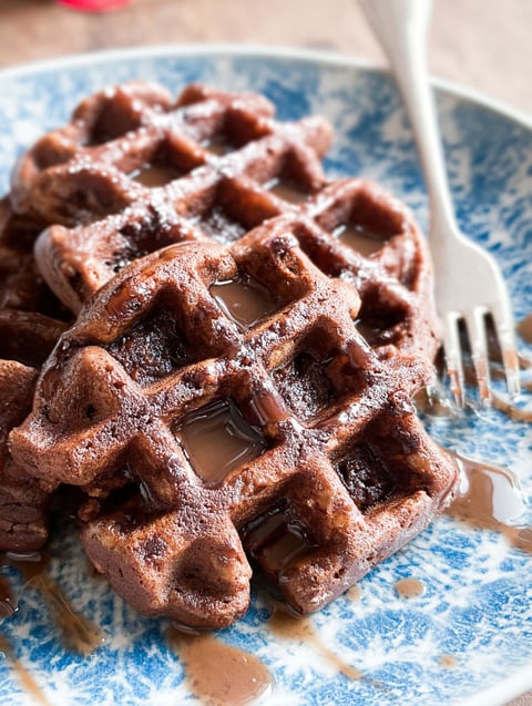Ein Teller mit Brownies und Sirup drauf.