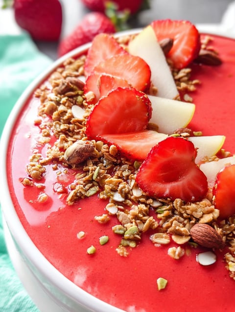 Ein Schälchen mit Erdbeer Smoothie und Toppings.