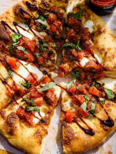 Ein Stück Bruschetta-Pizza mit Tomaten und Basilikum.