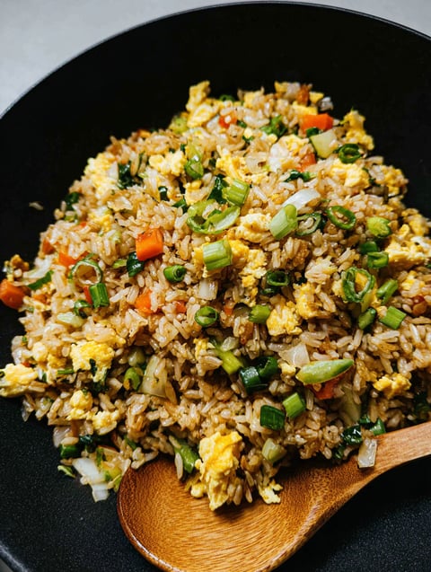 Ein Teller Reis mit Gemüse und Ei.